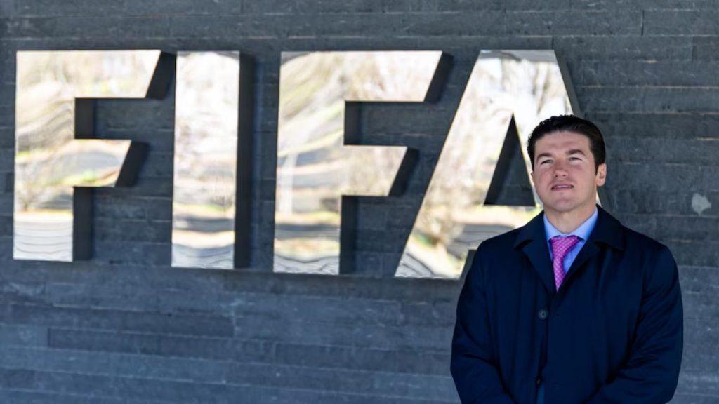 Samuel García Parado a Lado De Letrero De Fifa