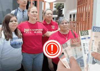 Five People Pose Outdoors, Three Women in Pink Shirts and Two Others, with Hands at the Right Showing Mexican Peso Bills and a Red Exclamation Icon. - Alcaldes Regios