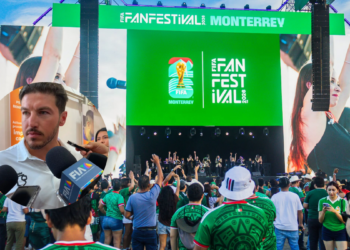Crowd Watches a Large Outdoor Stage with a Green Fifa Fan Fest Screen Reading Monterrey; People Raise Hands, Performers on Stage, and Big Screens on Sides Show Fans. - Alcaldes Regios